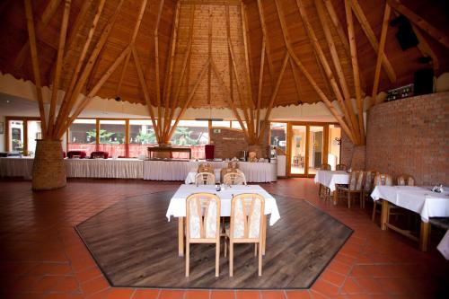a dining room with white tables and chairs at Hotel Makar Sport & Wellness in Pécs