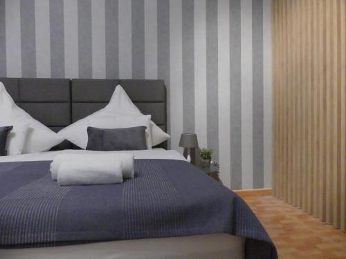 a bedroom with a large bed with blue and white pillows at White Stone Villa 43 in Promajna
