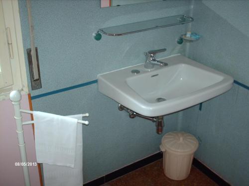 a bathroom with a white sink and a trash can at Hotel Triana e Tyche in Sasso Marconi