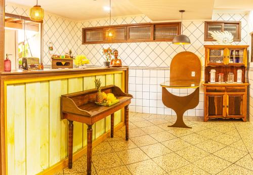 a kitchen with a table with a bowl of fruit on it at Pousada Casa do Oscar in Governador Celso Ramos