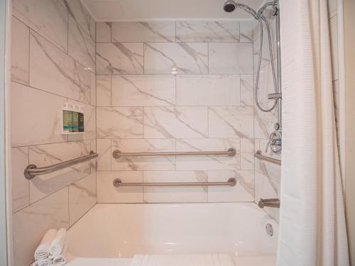 a white bathroom with a tub and a shower at Equus Inn I75 in Ocala
