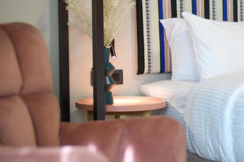 a bedroom with a bed and a table with a vase at Pavo Art Hotel in Heraklio Town