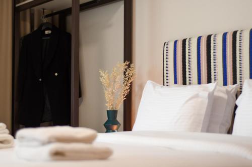 a bedroom with a bed with a mirror and a vase with flowers at Pavo Art Hotel in Heraklio Town