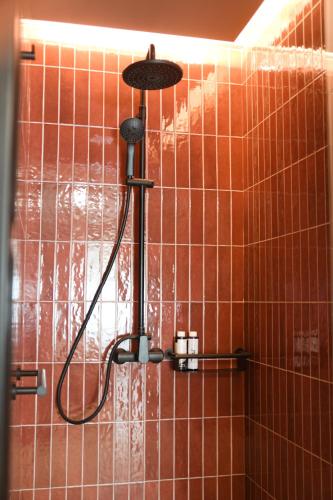 a shower in a bathroom with orange tiles at Pavo Art Hotel in Heraklio Town