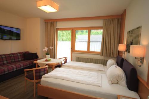 a hotel room with a bed and a living room at Haus Alexander in Schladming