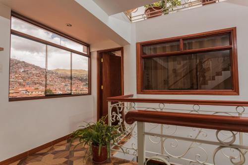 a balcony with two windows and a view of a city at Cozy Room Cusco in Cusco