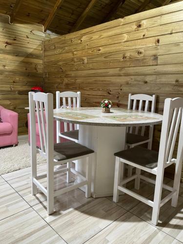 uma mesa branca e cadeiras num quarto em Cabana Refúgio canyon Malacara em Praia Grande