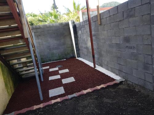 a patio with a brick wall next to a brick floor at lilie97418 in La Plaine des Cafres