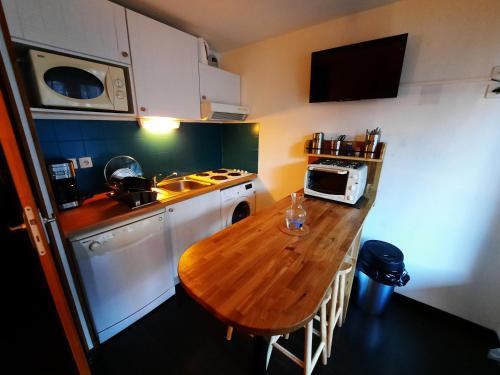 une petite cuisine avec une table en bois et un four micro-ondes dans l'établissement Studio du Benat, à Luz-Saint-Sauveur