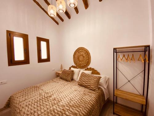 1 dormitorio con cama y lámpara de araña en Apartamentos Casa Anselmo EL TERRAO 