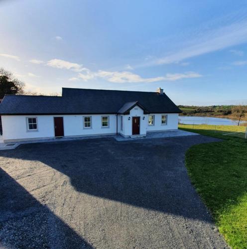 uma casa branca com uma entrada de cascalho em Claragh Cottage em Cavan