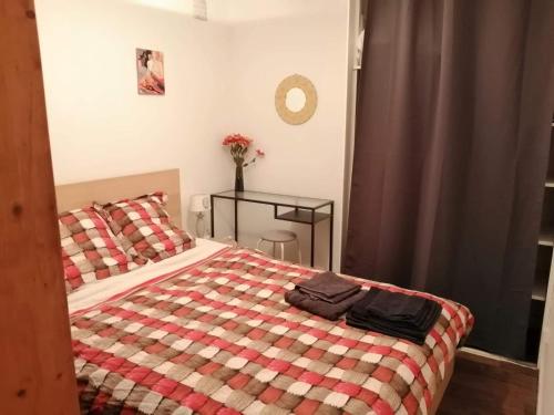 - une chambre avec un lit et une couverture en damier dans l'établissement Appartement T2 RDC centre Vitré 35500, à Vitré