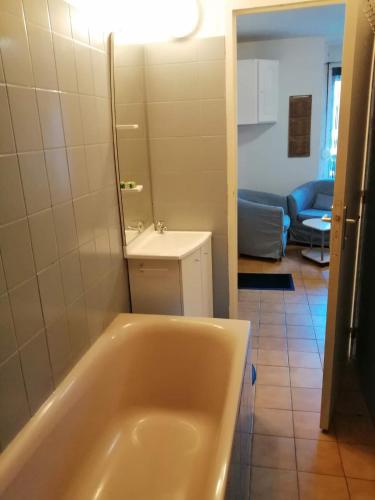 La salle de bains est pourvue d'une baignoire et d'un miroir. dans l'établissement Appartement T2 RDC centre Vitré 35500, à Vitré