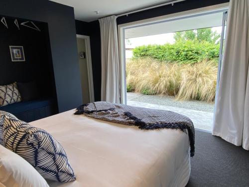 a bedroom with a bed and a large window at Mountain Vista Retreat - Apartment 1 in Twizel
