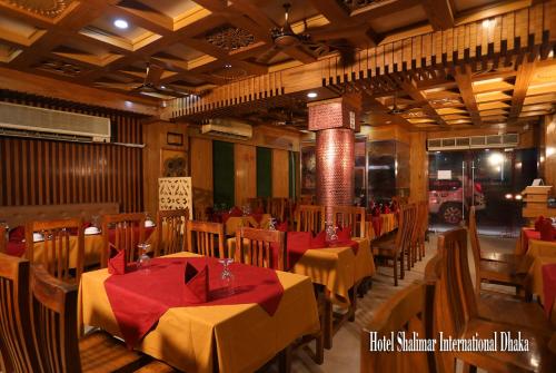 Hotel Shalimar Motijheel - Centre of City في داكا: مطعم فيه طاولات وكراسي في الغرفة