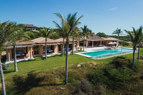 Una vista aérea de una casa con piscina y palmeras. en Casa Constantia Beach Front Villa, en Puerto Escondido