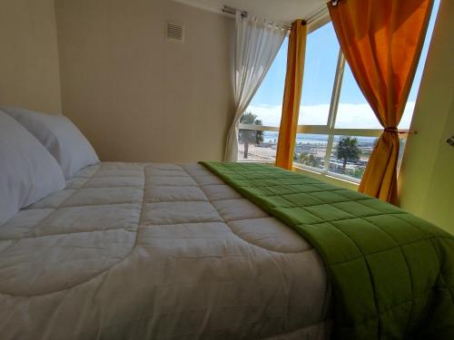 1 dormitorio con 1 cama grande y ventana grande en Departamento Maipu 501, en Coquimbo