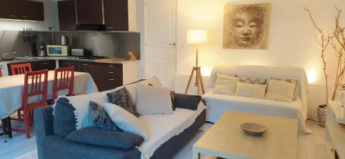 un salon avec un canapé et une table dans l'établissement Les Mondes - Appartement bas de maison, à Ensuès-la-Redonne