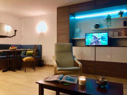 a living room with a couch and a tv and a table at Imowemo OVAR Multifuncional penthouse studios in Ovar