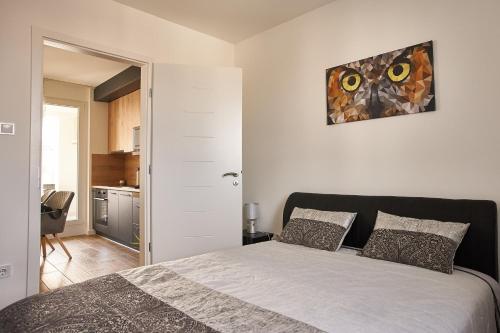 a bedroom with a bed and a painting on the wall at STARLIGHT SILVER Szeged - Exclusive in Szeged
