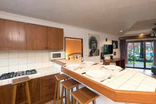a kitchen with a counter with chairs and a microwave at Sai Rougn Residence - SHA Extra Plus in Patong Beach