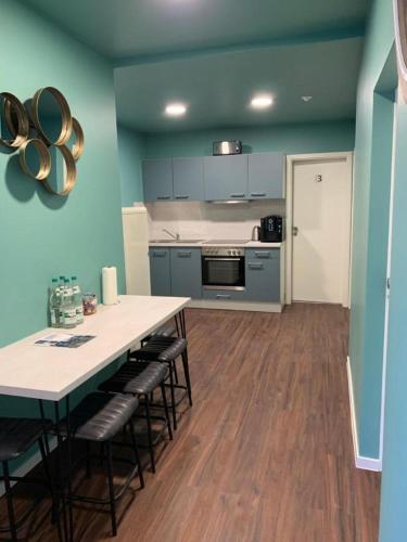 a kitchen with blue walls and a table and chairs at ARGENTA Living 16 in Künzell