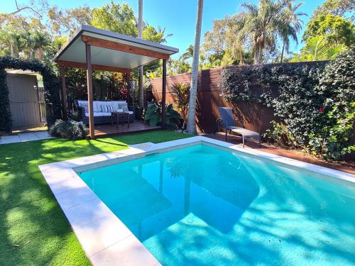a swimming pool in a yard with a gazebo at Pandanus Holiday Home in Coolum Beach