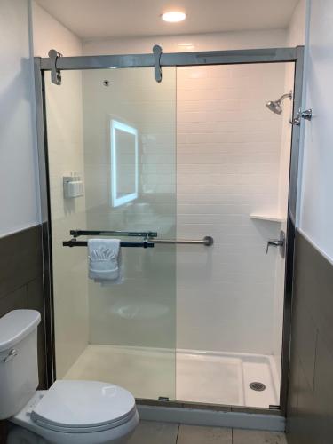 a bathroom with a glass shower with a toilet at Americas Best Value Inn Harlingen in Harlingen