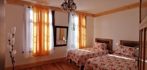 a bedroom with two beds and a window at La Casona del Buen dormir in Valdivia