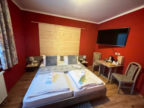 a bedroom with a bed and a flat screen tv at Berghotel Drei Brüder Höhe in Marienberg
