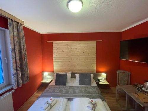 a bedroom with a bed with red walls at Berghotel Drei Brüder Höhe in Marienberg