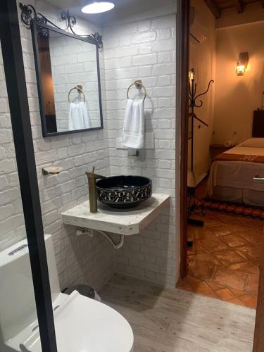 モンポスにあるBohemia Hotel Boutiqueの洗面台と鏡とベッドのあるバスルーム