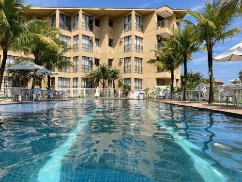une grande piscine devant un hôtel dans l'établissement apartamento na Reserva do Sahy em Mangaratiba RJ, à Mangaratiba
