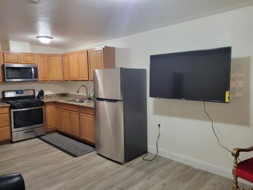 a kitchen with a refrigerator and a tv on the wall at Adorable 1 bedroom Apartment in Vallejo