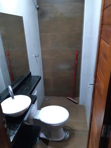 a bathroom with a toilet and a sink at Aconchego do Áureo in Pacoti
