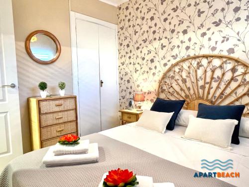 ein Schlafzimmer mit einem großen Bett und einem Spiegel in der Unterkunft APARTBEACH SAYONARA 125 Climatizado y Piscina in Salou
