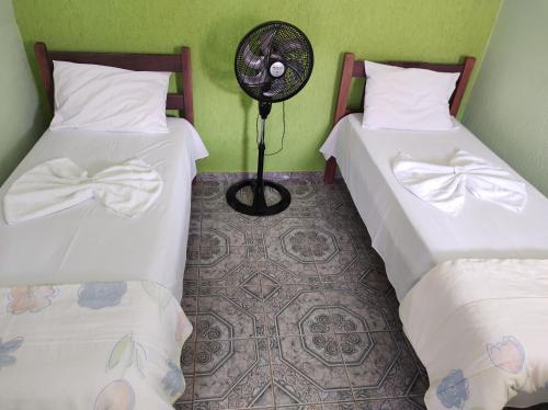 Habitación con 2 camas y ventilador. en Pousada Sol, en Cavalcante