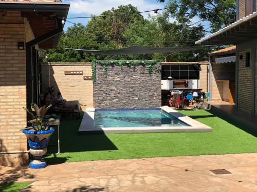 a backyard with a swimming pool and green grass at Alquiler San Bernardino Altos Loma grande in Loma Grande