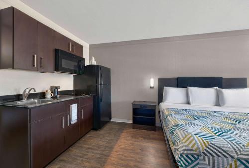a hotel room with a bed and a sink at Studio 6-Denton, TX - UNT in Denton