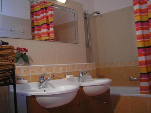 a bathroom with two sinks and a mirror at Vacation Apartment up to 10 in Bratislava