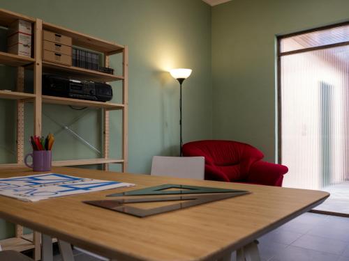 a room with a wooden table and a red chair at Petali di Toscana in Nugola