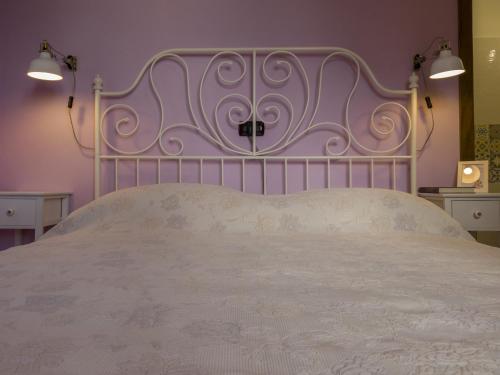 a bedroom with a white bed with a metal headboard at Petali di Toscana in Nugola