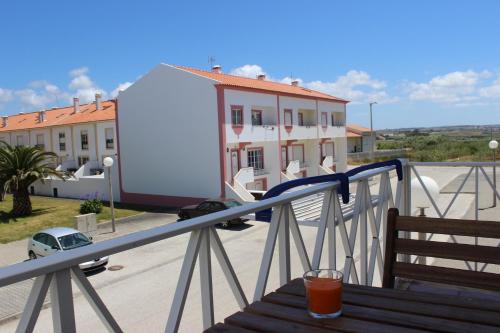 een drankje zittend op een houten tafel op een balkon bij Baleal Holiday Apartment in Baleal