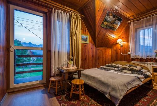 a bedroom with a bed and a large window at Pokoje u Sarnowskich in Kościelisko