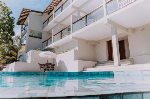 een villa met een zwembad en een huis bij Pousada Peninsula de Buzios in Búzios