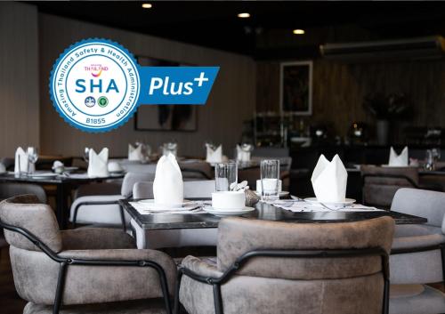 a restaurant with tables and chairs and a shka plus sign at KOS Hotel Suvarnabhumi Airport -SHA Extra Plus in Min Buri