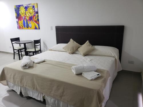 een slaapkamer met een groot bed en handdoeken bij Depto Guemes in Salta