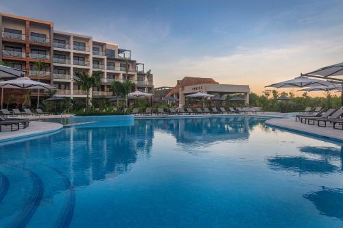 a swimming pool in front of a hotel at Ventus Ha at Marina El Cid Spa & Beach Resort - All Inclusive in Puerto Morelos