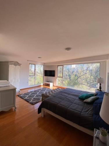 a bedroom with a large bed and a large window at Hermoso depa #3 Bosques de las Lomas. in Mexico City