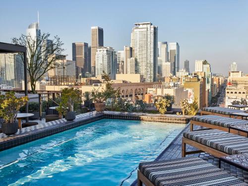 a swimming pool on top of a building with a city skyline at Downtown Los Angeles Proper Hotel, a Member of Design Hotels in Los Angeles